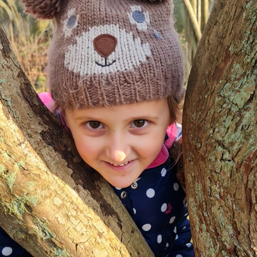 girl standing between a tree