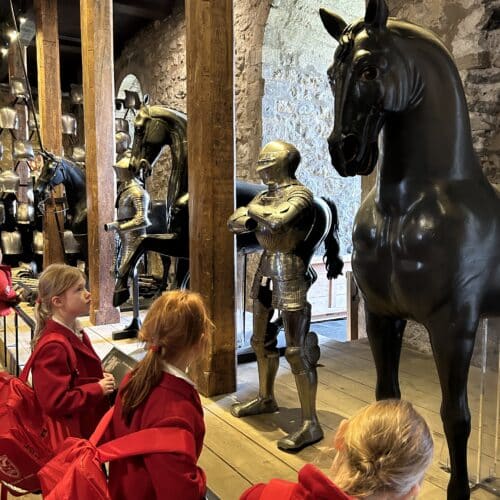 students looking at models of knights and horses