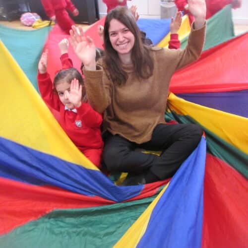 teacher and student sat on a parachute
