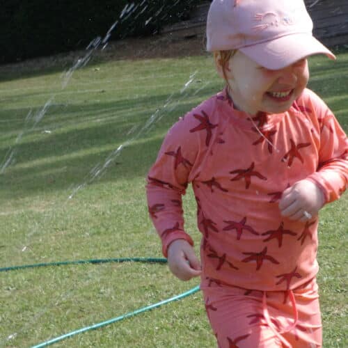 student playing with sprinklers