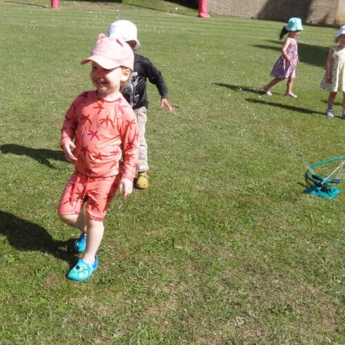 students playing with sprinklers