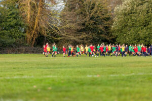 girls in coloured tops running house cross-country race at rothamsted park harpenden